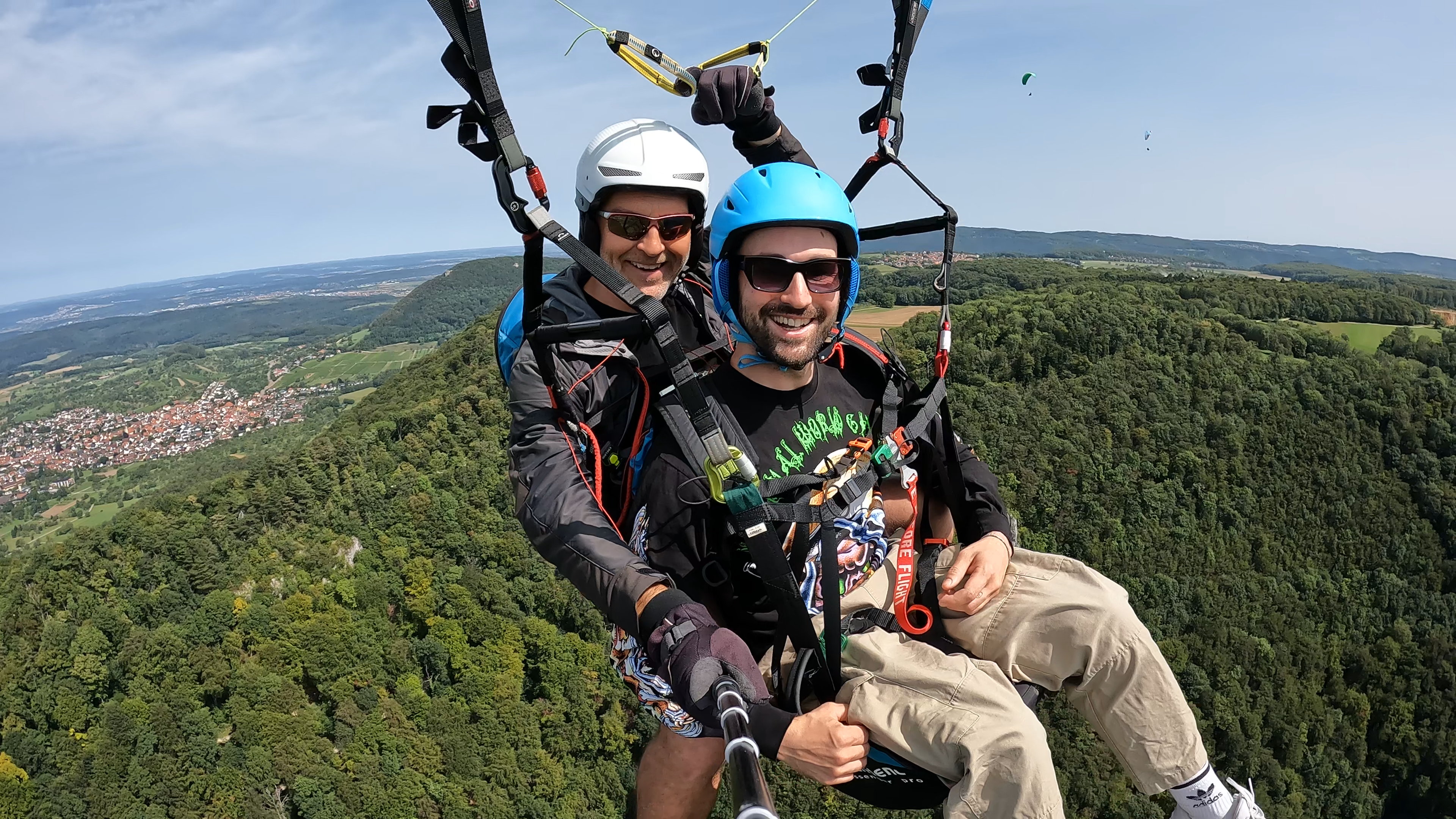 Tandemflug mit strahlendem Passagier über den Wäldern der Schwäbischen Alb