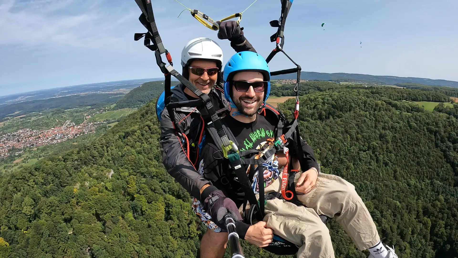 Tandemflug mit strahlendem Passagier über den Wäldern der Schwäbischen Alb