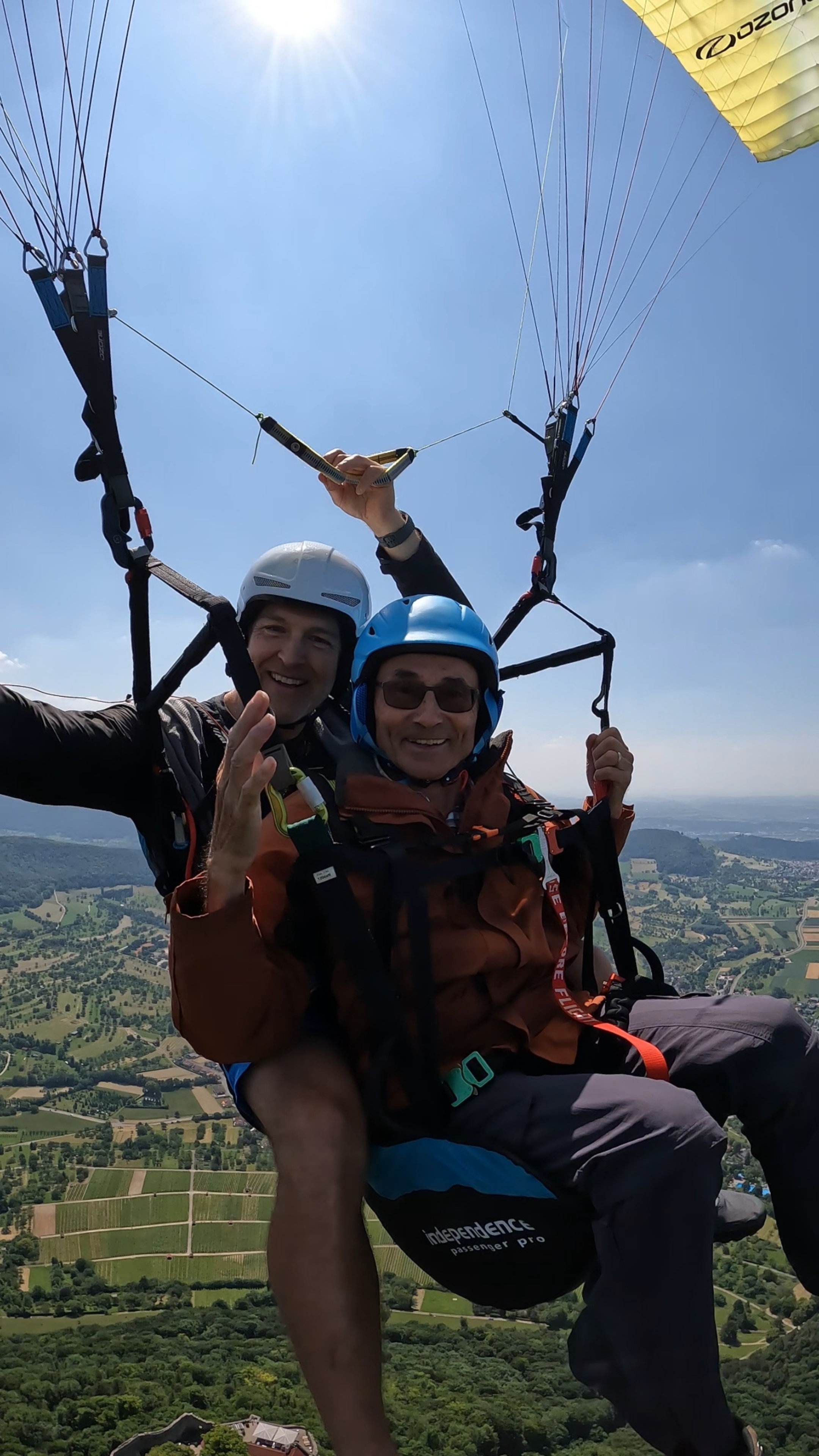Zufriedener Passagier genießt den Tandemflug über sonnigen Weinbergen